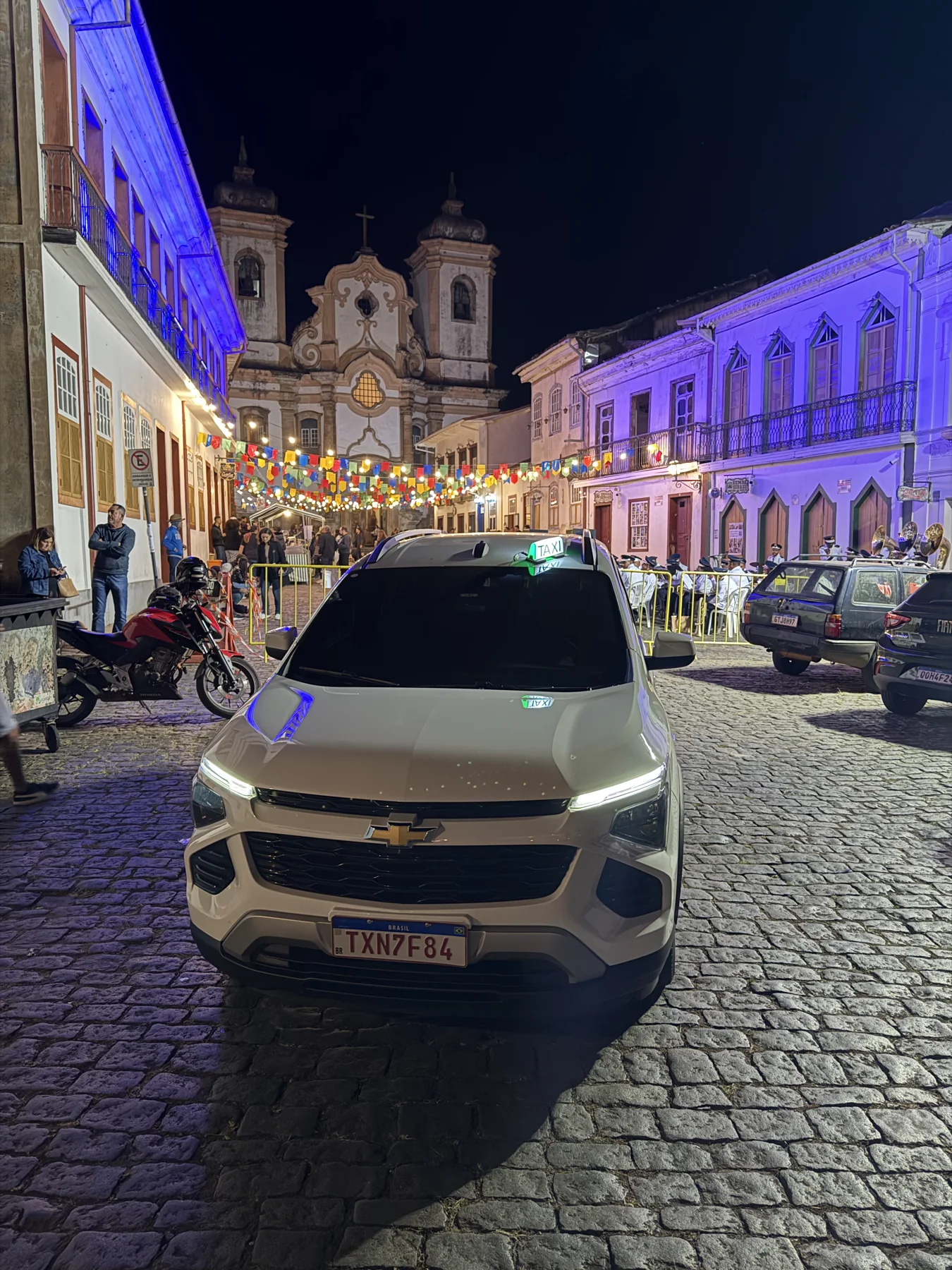 Veículo branco da RT Executivo em uma rua iluminada à noite